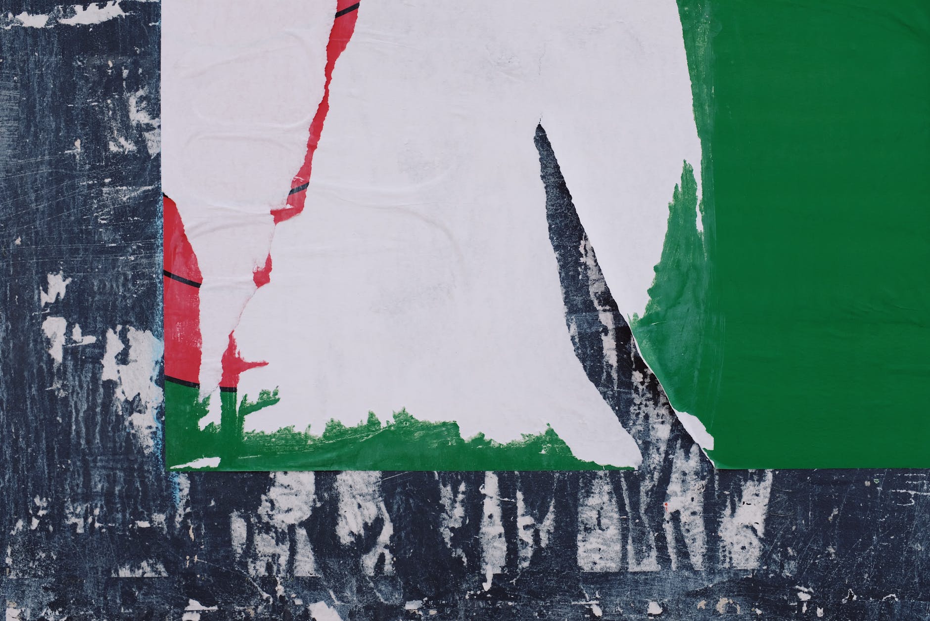 old torn poster placed on shabby wall